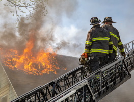 Image of firefighters on ladder at a fire